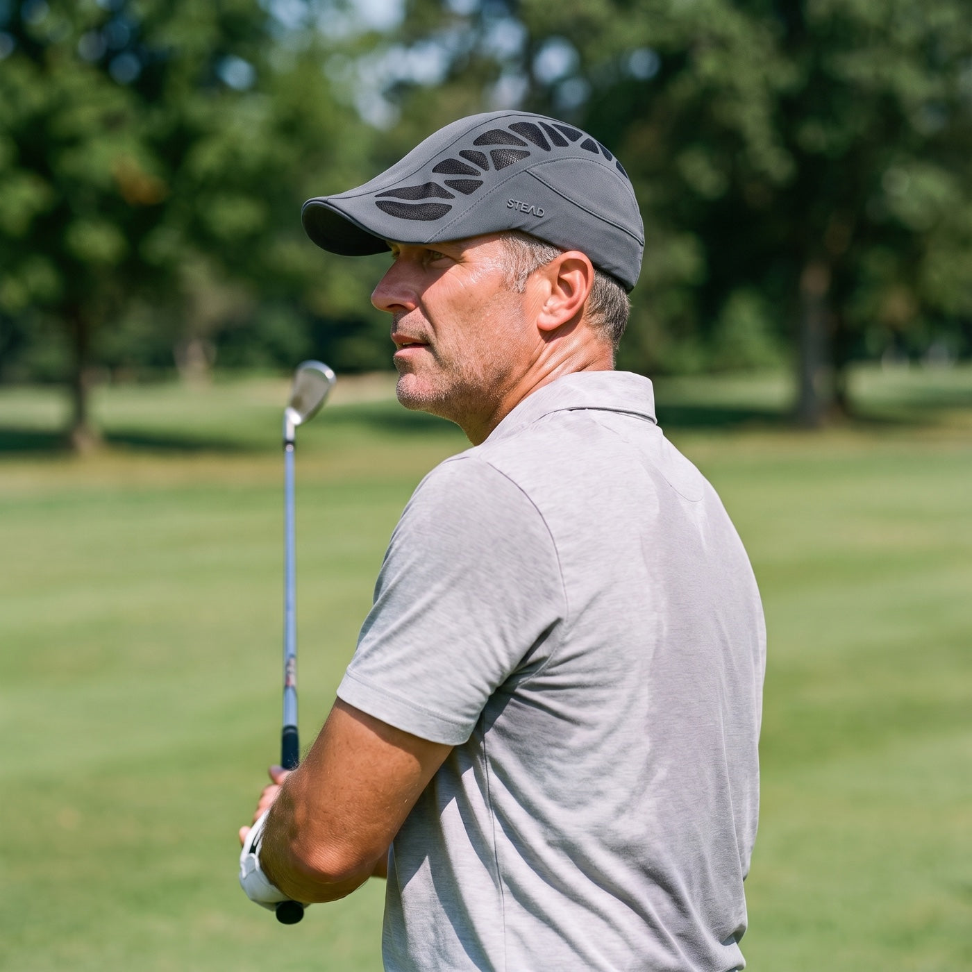 A man on a golf course in the hot sun, in the Aeromesh Evo Cap